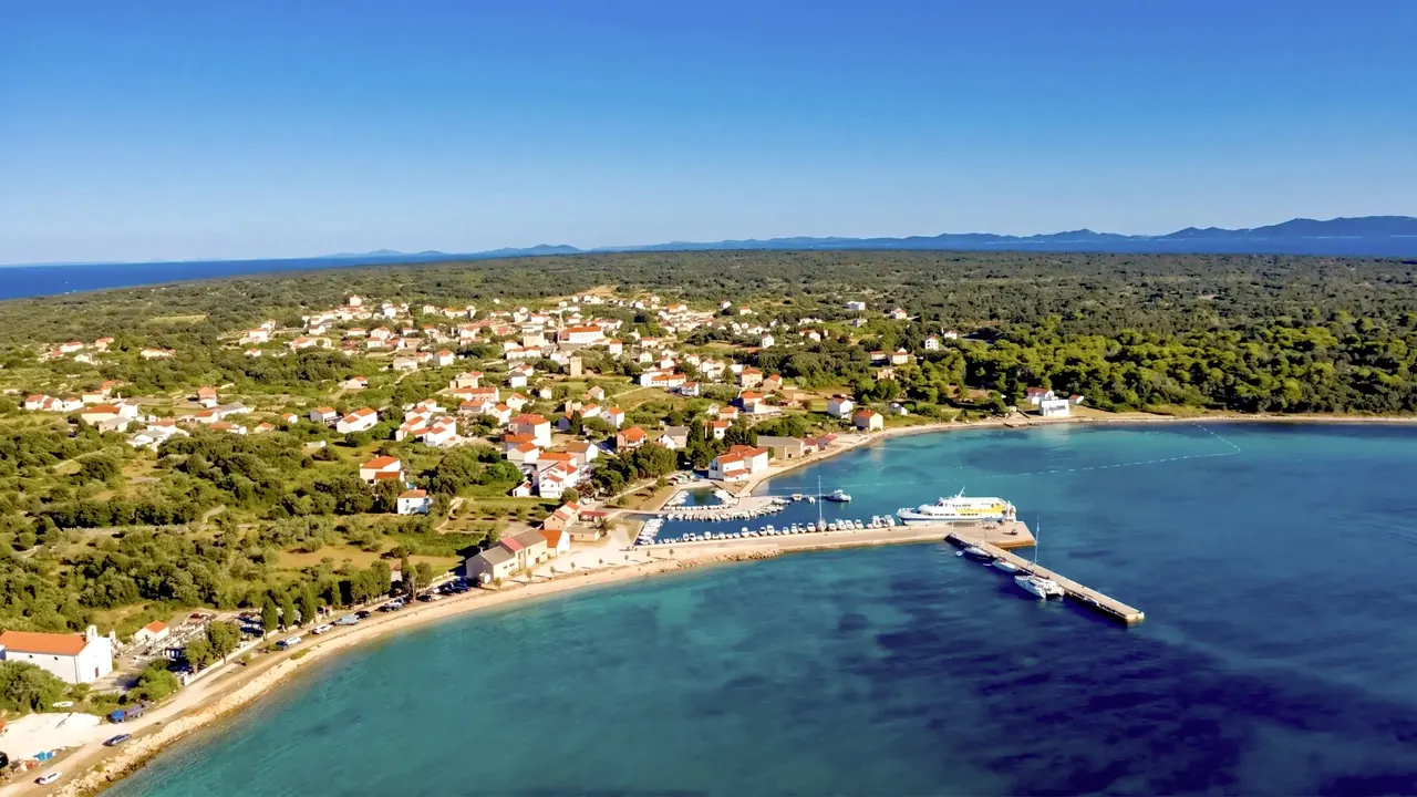 Aerial view of Olib village with red roofs, the harbour and the ferry pier